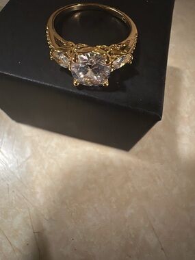 Gold-tone  with a baby blue Cubic  Zirconia  in the center . Glimmering Ring